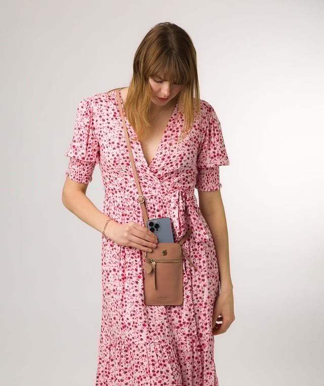 The 'Bambino' cross body phone bag from Conkca London is handcrafted from multi-toned leather for a beautiful finish. A zip-over top opens to reveal the main compartment that is the perfect size for a smartphone, lined with natural and untreated 100% cotton. Features a zipped pocket on the front and a slip pocket on the rear, ideal for small essentials. Comes with an adjustable leather strap with a maximum drop length of 70cm. Adorned with the inimitable Conkca squirrel charm and Conkca logos.