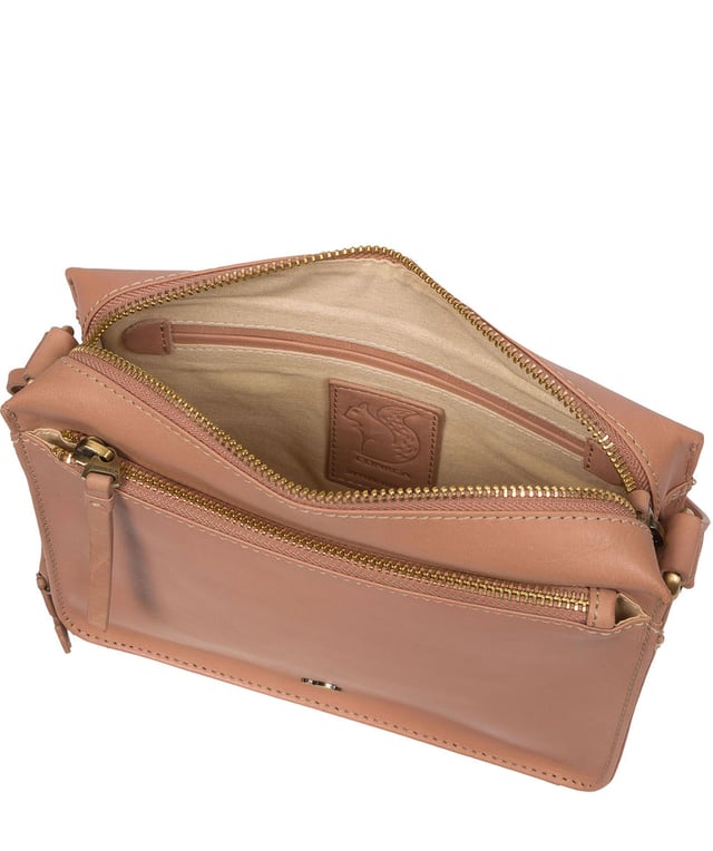 The 'Aurora' cross body bag from Conkca London elevates this classic design with a natural leather exterior for a beautifully smooth finish. A zip-over top conceals the central 100% cotton lined compartment alongside a handy slip pocket. Additional storage space is provided by a zipped pocket and slip pocket, ideal for on-the-go storage. The accessory comes with an adjutable leather strap secured with rustic gold metal fittings; this is all finished with the iconic Conkca London logo and charm.