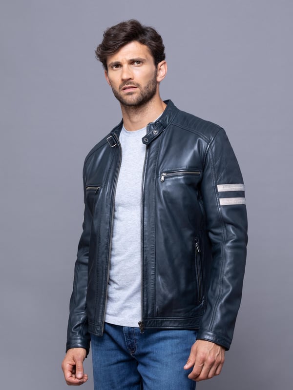 With all the hallmarks of a Lakeland favourite jacket, Charlie is a contemporary update to a traditional cafe racer design.
A slim fit biker inspired jacket with a cafe racer classic silhouette, buckle press stud collar, press stud cuffs and side fastening and contrasting stripe. For fans of the motorcycle era this jacket gives a nod to the racing heritage. The striking navy design with quilted shoulder stitching and coloured leather stripes on the sleeve is crafted from UK sourced aniline leather for a soft sheen. The Charlie biker is a garment that will age beautifully the more you wear it, creating a fit unique to the wearer.