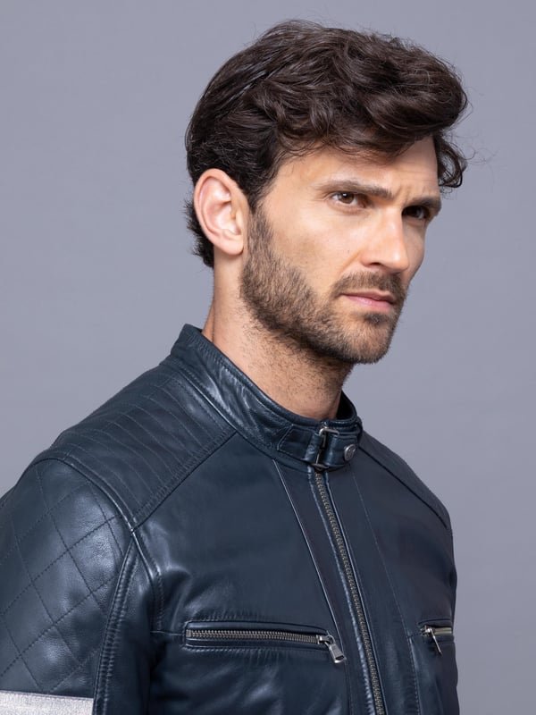 With all the hallmarks of a Lakeland favourite jacket, Charlie is a contemporary update to a traditional cafe racer design.
A slim fit biker inspired jacket with a cafe racer classic silhouette, buckle press stud collar, press stud cuffs and side fastening and contrasting stripe. For fans of the motorcycle era this jacket gives a nod to the racing heritage. The striking navy design with quilted shoulder stitching and coloured leather stripes on the sleeve is crafted from UK sourced aniline leather for a soft sheen. The Charlie biker is a garment that will age beautifully the more you wear it, creating a fit unique to the wearer.