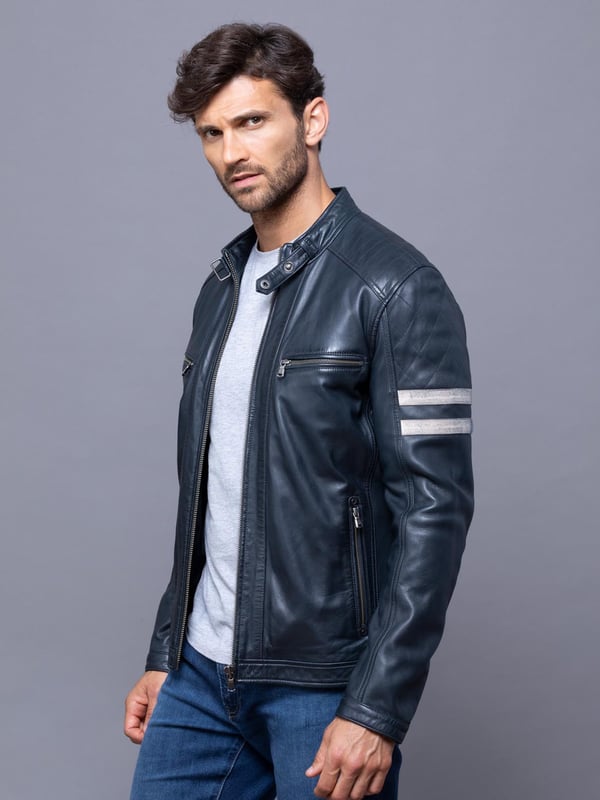 With all the hallmarks of a Lakeland favourite jacket, Charlie is a contemporary update to a traditional cafe racer design.
A slim fit biker inspired jacket with a cafe racer classic silhouette, buckle press stud collar, press stud cuffs and side fastening and contrasting stripe. For fans of the motorcycle era this jacket gives a nod to the racing heritage. The striking navy design with quilted shoulder stitching and coloured leather stripes on the sleeve is crafted from UK sourced aniline leather for a soft sheen. The Charlie biker is a garment that will age beautifully the more you wear it, creating a fit unique to the wearer.