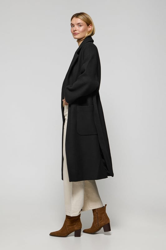 Unser Damenmantel Carrie ist ideal für alle, die ein vielseitiges und stilvolles Kleidungsstück suchen. Das Oversized-Design mit spitzem Reverskragen und langen Ärmeln schafft eine entspannte Silhouette. Der abnehmbare Gürtel ermöglicht es Ihnen, den Mantel an Ihren gewünschten Stil anzupassen, während die beiden Vordertaschen praktischen Stauraum bieten. Die beiden Seitenschlitze sorgen für Bewegungsfreiheit. Das Polo Club Logo auf der Passe unterstreicht den exklusiven Charakter des Mantels. Perfekt für den Alltag oder besondere Anlässe.