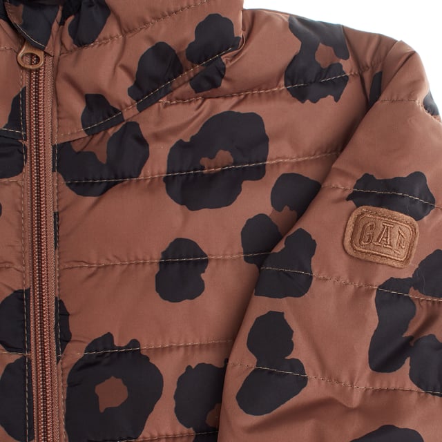 Gap girls' quilted jacket, designed with lightweight padding that provides warmth without adding bulk.

 It features a convenient front zip closure for easy dressing, plus a hood that adds extra protection on cold days.

 French-style front pockets offer convenience and a touch of style.

 One of the sleeves features the brand's logo with visible matching stitching.

 Made from 100% recycled polyester, this jacket is part of the Gap for Good initiative, committed to sustainability.

 It uses recycled materials to reduce the impact on natural resources, taking care of both the well-being of girls and the planet.
 Composition: Body: 100% Polyester; Cover: Acrylic; Inner: 100% Polyester; Filling: 100% Polyester
 Care:
- Machine wash cold on delicate cycle.
 - Use non-chlorine bleach when necessary.
 - Do not dry clean.