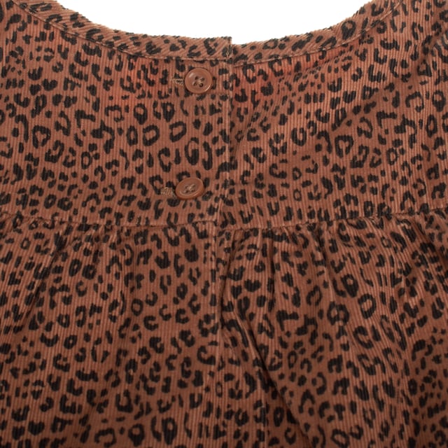 Este encantador vestido de pana para niñas, confeccionado en suave tejido de algodón, además con un forro interno que asegura mayor comodidad y calidez. 

Su diseño con cuello redondo y cierre de botones en la espalda aporta un toque delicado y funcional, facilitando el uso. 

Las mangas largas lo hacen ideal para los días frescos, mientras que el dobladillo escalonado añade un detalle moderno y femenino.

El vestido presenta un llamativo estampado animal print, que le da un toque divertido y a la moda, perfecto para cualquier ocasión. 

Con una silueta recta de ajuste fácil, garantiza libertad de movimiento, y su longitud hasta la rodilla lo convierte en una opción cómoda y versátil, ideal tanto para el día a día como para momentos más especiales.

Una prenda hecha en algodón que cuida la piel y ofrece suavidad, perfecta para que las niñas se sientan cómodas y llenas de estilo.
 Composición: Exterior: 100% Algodón; Forro: 100% Algodón
 Cuidados:
- Lavar a máquina en ciclo suave o a mano.
- Usar detergentes suaves.
- No usar secadora.
- Planchar a bajas temperaturas.
- Planchar en seco.