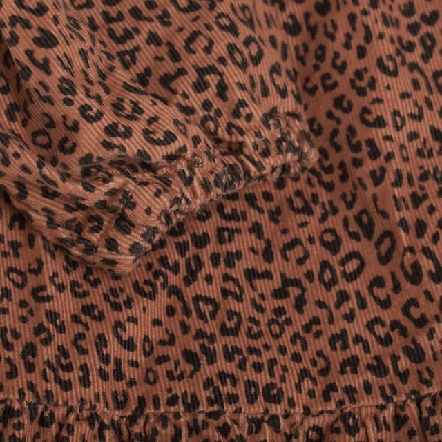 Este encantador vestido de pana para niñas, confeccionado en suave tejido de algodón, además con un forro interno que asegura mayor comodidad y calidez. 

Su diseño con cuello redondo y cierre de botones en la espalda aporta un toque delicado y funcional, facilitando el uso. 

Las mangas largas lo hacen ideal para los días frescos, mientras que el dobladillo escalonado añade un detalle moderno y femenino.

El vestido presenta un llamativo estampado animal print, que le da un toque divertido y a la moda, perfecto para cualquier ocasión. 

Con una silueta recta de ajuste fácil, garantiza libertad de movimiento, y su longitud hasta la rodilla lo convierte en una opción cómoda y versátil, ideal tanto para el día a día como para momentos más especiales.

Una prenda hecha en algodón que cuida la piel y ofrece suavidad, perfecta para que las niñas se sientan cómodas y llenas de estilo.
 Composición: Exterior: 100% Algodón; Forro: 100% Algodón
 Cuidados:
- Lavar a máquina en ciclo suave o a mano.
- Usar detergentes suaves.
- No usar secadora.
- Planchar a bajas temperaturas.
- Planchar en seco.