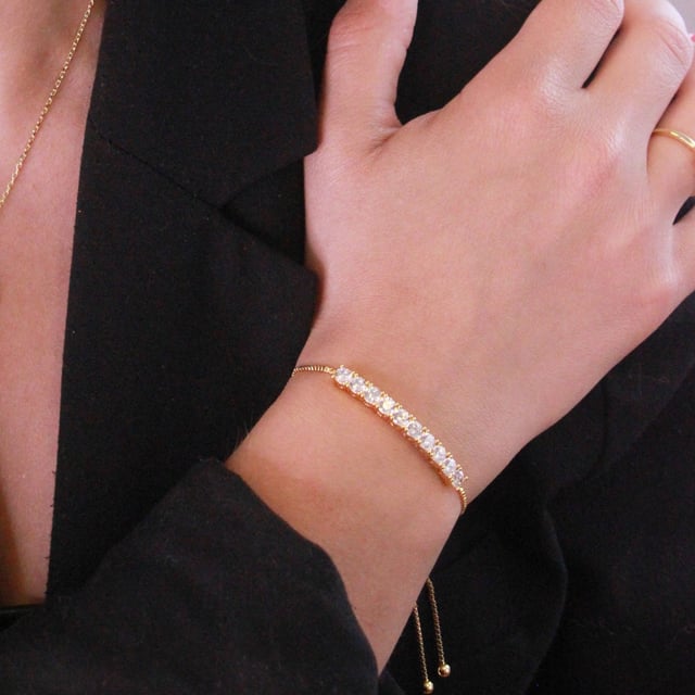 Samenstelling: Messing Afwerking: 18k verguld Steensoort: Oostenrijks kristal Steensoort: Witte zirkoon Aantal stenen (stuks): 86 Steenkleur: Kristal Lengte ketting: Lengte ketting (mm): 400 + 50 Diameter oorbellen (mm): 14 Lengte armband (mm): 245