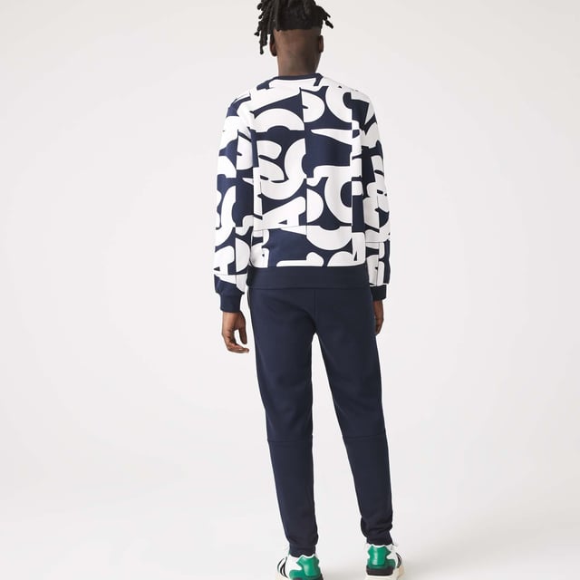 Men's Lacoste Branded Bands Skinny Fleece Joggers.- Brushed cotton blend fleece.- Elasticised waistband.- Tapered fit.- Tapered cut.- Side pockets, ribbed finishes on leg bottoms and Lacoste branding on stripes on sides.- Embroidered green crocodile on hip. Material: 83% Cotton, 17% Polyester. Ref: XH1208166.