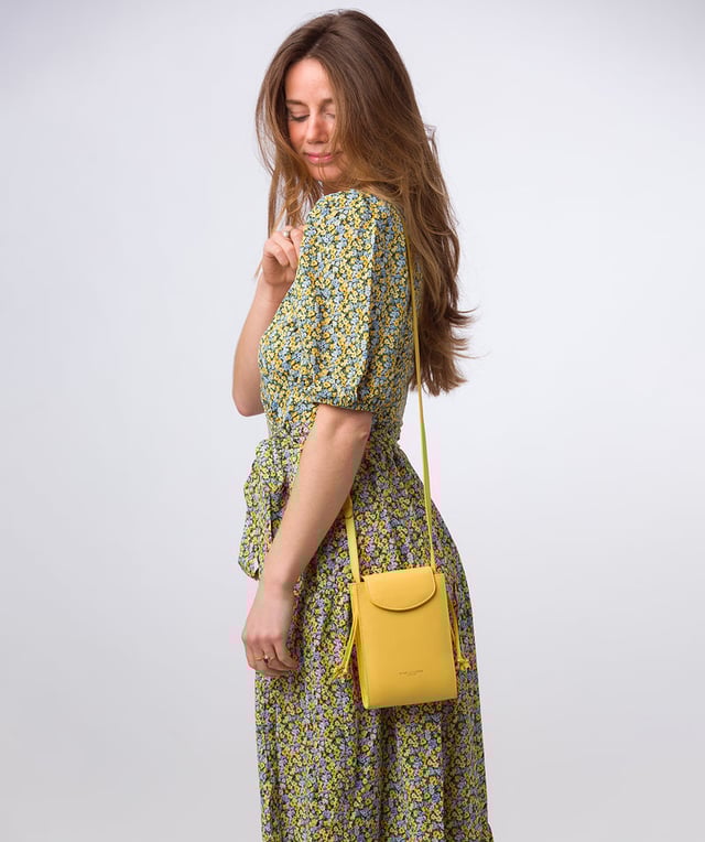The 'Kiana' cross body phone bag from the Pure Luxuries Marylebone Collection is handcrafted from high-quality, genuine Nappa leather with a natural super-soft touch. The minimalistic fold-over top is secured by a gold-coloured magnetic press stud. This practical design is the perfect place to keep your phone safe and features a tassel design on the exterior. Lined with 100% cotton for a flawless finish and comes with a matching and adjustable slim leather strap with a maximum drop length of 65cm. The minimalist Pure Luxuries logo is embossed in gold foil for a beautifully simple finishing touch.