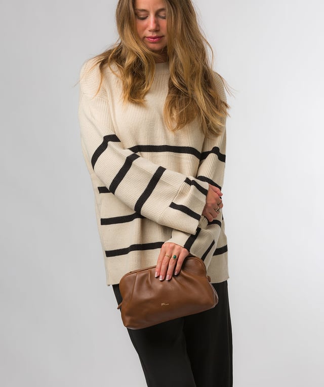 The 'Halsey' cross body clutch bag from Pure Luxuries London's Knightsbridge Collection is handcrafted from gold standard Nappa leather with a super-soft and smooth finish. The zip-over top opens to reveal a 100% cotton interior. The spacious compartment features four card slots to help maintain an organised bag. Comes with an adjustable and removable slim leather strap, with a maximum drop length of 65cm. Features gold-coloured metal fittings and zips. The minimalist Pure Luxuries logo is embossed in gold foil for a beautifully simple finishing touch.
