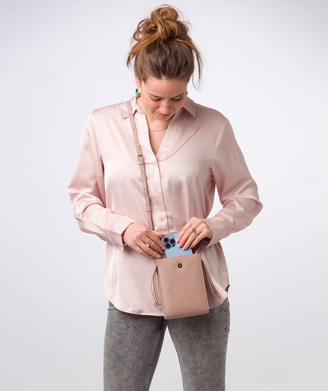 The 'Kiana' cross body phone bag from the Pure Luxuries Marylebone Collection is handcrafted from high-quality, genuine Nappa leather with a natural super-soft touch. The minimalistic fold-over top is secured by a gold-coloured magnetic press stud. This practical design is the perfect place to keep your phone safe and features a tassel design on the exterior. Lined with 100% cotton for a flawless finish and comes with a matching and adjustable slim leather strap with a maximum drop length of 65cm. The minimalist Pure Luxuries logo is embossed in gold foil for a beautifully simple finishing touch.