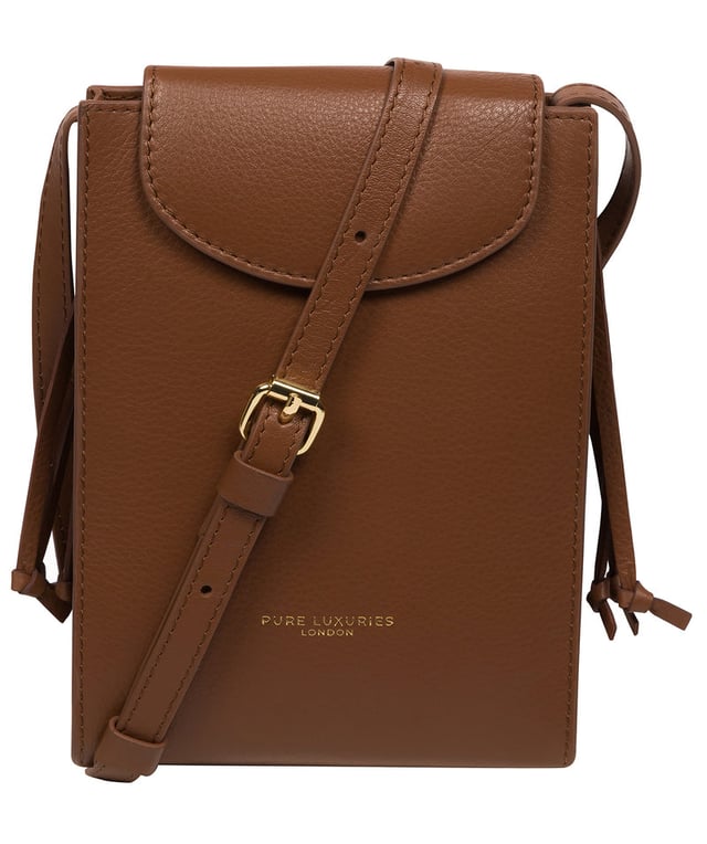 The 'Kiana' cross body phone bag from the Pure Luxuries Marylebone Collection is handcrafted from high-quality, genuine Nappa leather with a natural super-soft touch. The minimalistic fold-over top is secured by a gold-coloured magnetic press stud. This practical design is the perfect place to keep your phone safe and features a tassel design on the exterior. Lined with 100% cotton for a flawless finish and comes with a matching and adjustable slim leather strap with a maximum drop length of 65cm. The minimalist Pure Luxuries logo is embossed in gold foil for a beautifully simple finishing touch.