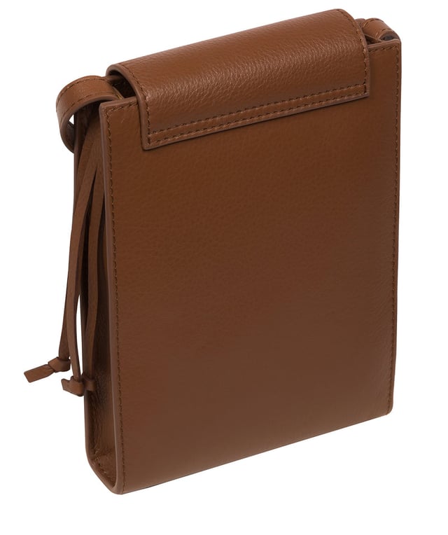 The 'Kiana' cross body phone bag from the Pure Luxuries Marylebone Collection is handcrafted from high-quality, genuine Nappa leather with a natural super-soft touch. The minimalistic fold-over top is secured by a gold-coloured magnetic press stud. This practical design is the perfect place to keep your phone safe and features a tassel design on the exterior. Lined with 100% cotton for a flawless finish and comes with a matching and adjustable slim leather strap with a maximum drop length of 65cm. The minimalist Pure Luxuries logo is embossed in gold foil for a beautifully simple finishing touch.