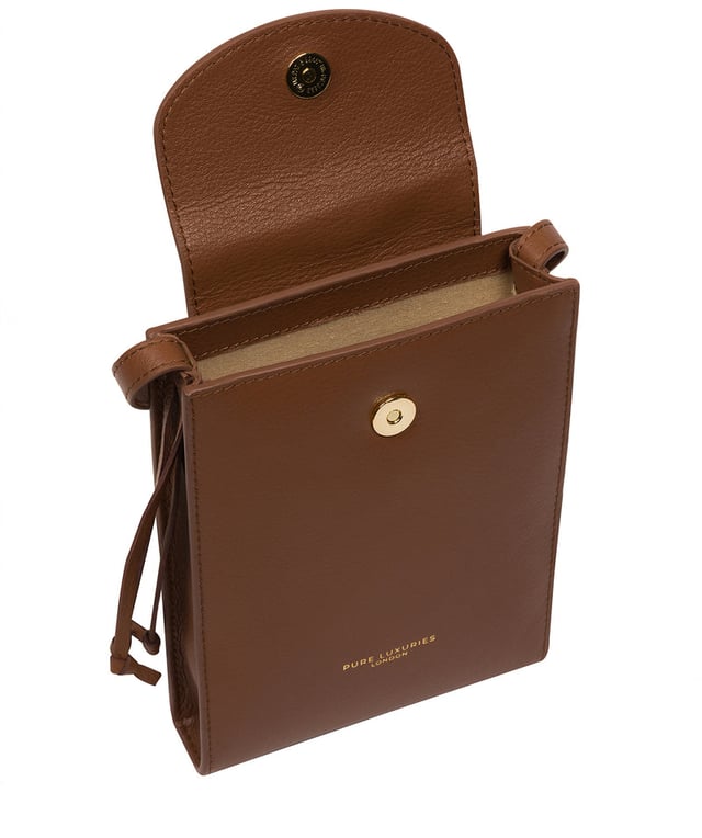 The 'Kiana' cross body phone bag from the Pure Luxuries Marylebone Collection is handcrafted from high-quality, genuine Nappa leather with a natural super-soft touch. The minimalistic fold-over top is secured by a gold-coloured magnetic press stud. This practical design is the perfect place to keep your phone safe and features a tassel design on the exterior. Lined with 100% cotton for a flawless finish and comes with a matching and adjustable slim leather strap with a maximum drop length of 65cm. The minimalist Pure Luxuries logo is embossed in gold foil for a beautifully simple finishing touch.