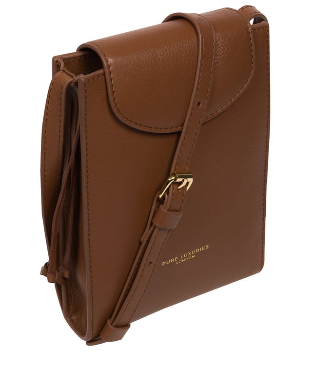 The 'Kiana' cross body phone bag from the Pure Luxuries Marylebone Collection is handcrafted from high-quality, genuine Nappa leather with a natural super-soft touch. The minimalistic fold-over top is secured by a gold-coloured magnetic press stud. This practical design is the perfect place to keep your phone safe and features a tassel design on the exterior. Lined with 100% cotton for a flawless finish and comes with a matching and adjustable slim leather strap with a maximum drop length of 65cm. The minimalist Pure Luxuries logo is embossed in gold foil for a beautifully simple finishing touch.