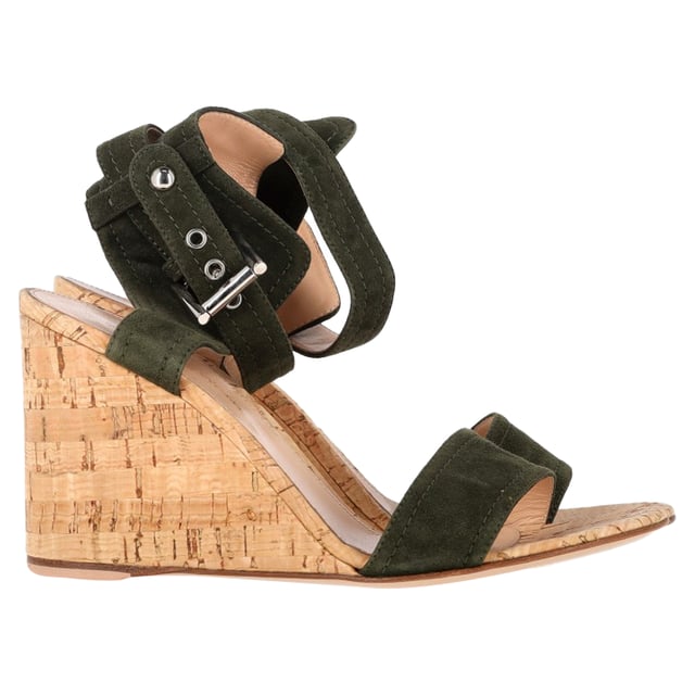 VINTAGE, UVP WIE NEU  
Diese Gianvito Rossi Sandalen umschmeicheln Ihre Füße auf elegante Weise. Gefertigt aus Wildleder, präsentieren sie einen einzigen Riemen auf dem Vorderfuß, einen Knöchelverschluss mit Schnalle und einen Keilabsatz aus Kork. Geschlossene Fersen und offene Zehen verleihen diesem Paar das gewisse Etwas.

Gianvito Rossi Portofino Keilabsatz in grünem Wildleder  
Zustand: Ausgezeichnet  
Tragespuren: Keine sichtbaren Tragespuren. Kein Makel an der Innensohle, sehr leichter Makel an den Sohlen.  
Verpackung: Keine  
Farbe: Grün  
Material: Wildleder  
Größe: EU | 38,5/US8,5  
Maße: Absatzhöhe: 90; Innensohlenlänge: 220  
SKU: NAPPUGBSH457188W