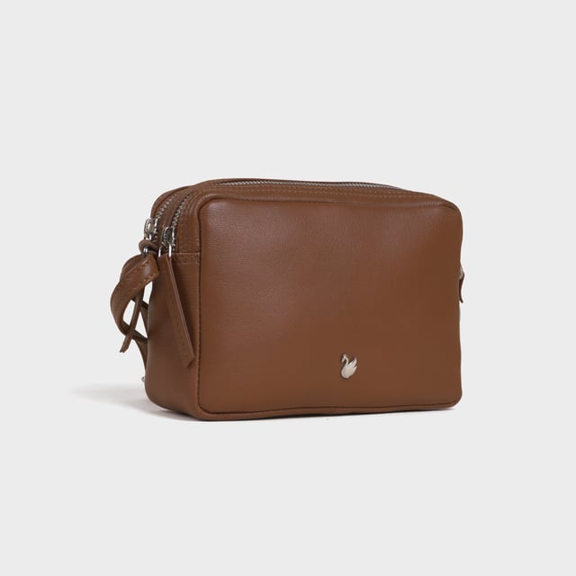 Redefine elegance with the ‘Avon’ soft Nappa leather crossbody bag, a perfect fusion of luxury, craftsmanship, and practicality. Expertly handcrafted from the finest full-grain soft Nappa leather, this premium bag is designed for those who appreciate timeless sophistication and effortless style. Whether you're heading to work, a casual outing, or an evening event, the ‘Avon’ crossbody bag is your go-to accessory for effortless sophistication and refined style. Premium Full-Grain Nappa Leather – Crafted from the softest and most supple genuine leather, offering a luxurious touch and exceptional durability. Smart & Functional Design – Double zipped compartments for easy organisation and secure storage. Spacious interior to accommodate your daily essentials with ease. Adjustable Leather Shoulder Strap – Designed for custom comfort, allowing you to wear it as a crossbody or shoulder bag. Lightweight & Versatile – A perfect everyday companion, seamlessly blending style and functionality. Signature Assots ‘Swan’ Collection – Embellished with the iconic ‘Swan’ logo, symbolising elegance, grace, and superior craftsmanship. Additional Internal Features - Slip-in pocket for your mobile phone, car keys and house keys. Fittings Colour: Silver. Composition: Body: 100% Genuine Leather, Lining: Polyester. Size: 14cm x 20cm x 7cm