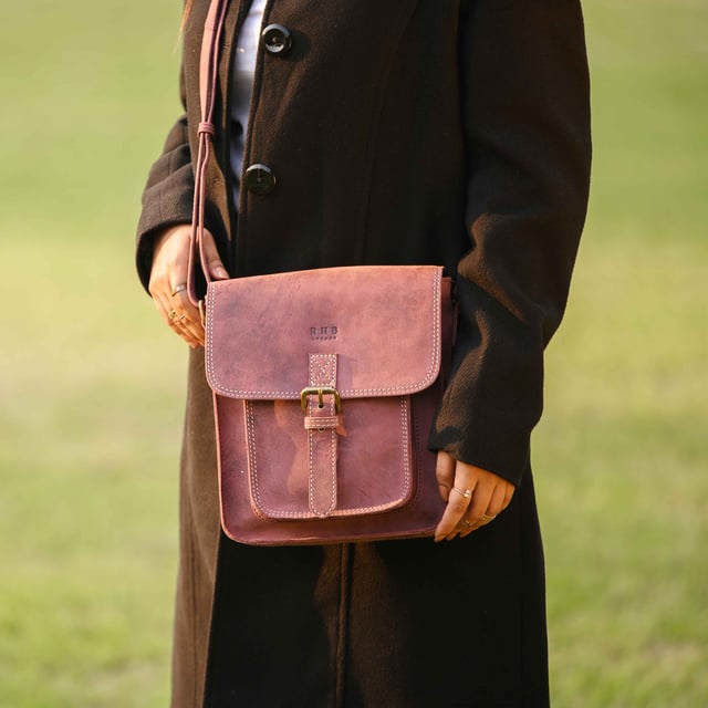 Introducing 'Carolyn', the ultimate luxury handbag crafted from the finest real leather. Featuring a sophisticated flap closure with magnetic fastening, 'Carolyn' is as beautifully structured as it is stylish, with three large compartments for all your essentials. Perfect for any occasion, 'Carolyn' is your perfect companion for effortless elegance. Secured magnetic flap closure. Opens to three roomy main compartments to slide in your tablet, ipad, notebooks and more. Fully lined interiors in natural beige polyester fabric. Zipped middle compartment to slide in your mobile phone, car keys, house keys and more. 
Full width back zip pocket provides extra space for organising your essentials. Lightweight. Mock buckle on the front for that designer sophisticated look. 
Slider adjustable leather shoulder handle for a comfortable carry. Graced with the Signature 'Real Hide Bag' insignia, the iconic RHB emboss is intricately etched into the exterior of the front flap. Fittings Colour: Antique Brass. Composition: Body: 100% Genuine Leather. Lining: Polyester.
DISCLAIMER : All pictures shown are for illustration purpose only. Actual product colour may vary due to different ambience lighting or the screen display settings. Size- W25cm x H21cm x D7cm.