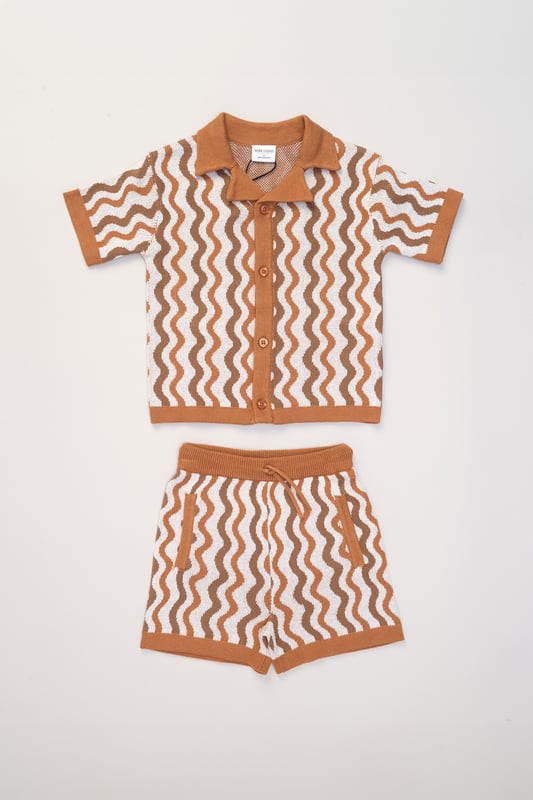 This True Knit resort shirt and shorts set from Norn Studios features a cool patterned design, perfect for summer days and getaways. The lightweight, breathable fabric keeps your little one cool, while the matching shorts complete the relaxed, vacation-ready look. Ideal for sunny adventures and laid-back afternoons.