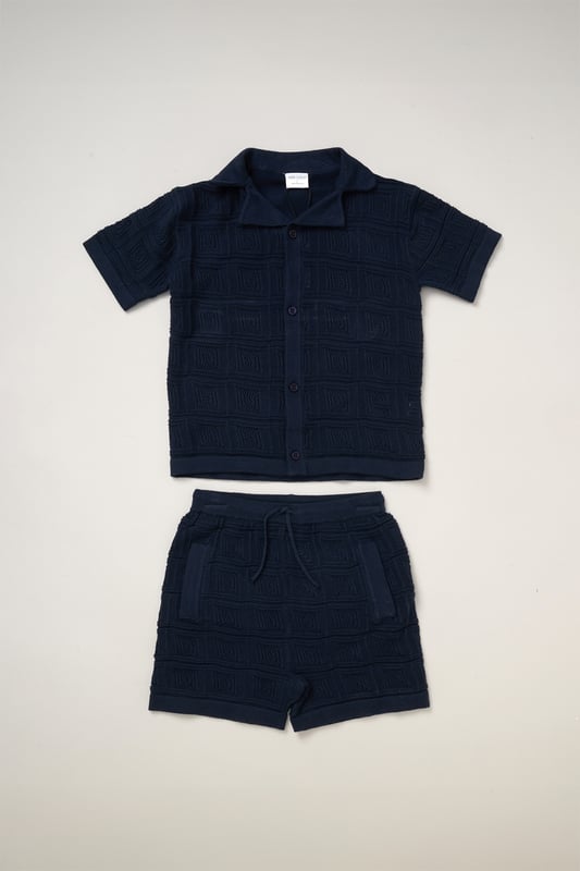 This True Knit resort shirt and shorts set from Norn Studios features a cool patterned design, perfect for summer days and getaways. The lightweight, breathable fabric keeps your little one cool, while the matching shorts complete the relaxed, vacation-ready look. Ideal for sunny adventures and laid-back afternoons.