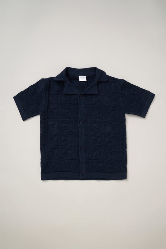 This True Knit resort shirt and shorts set from Norn Studios features a cool patterned design, perfect for summer days and getaways. The lightweight, breathable fabric keeps your little one cool, while the matching shorts complete the relaxed, vacation-ready look. Ideal for sunny adventures and laid-back afternoons.