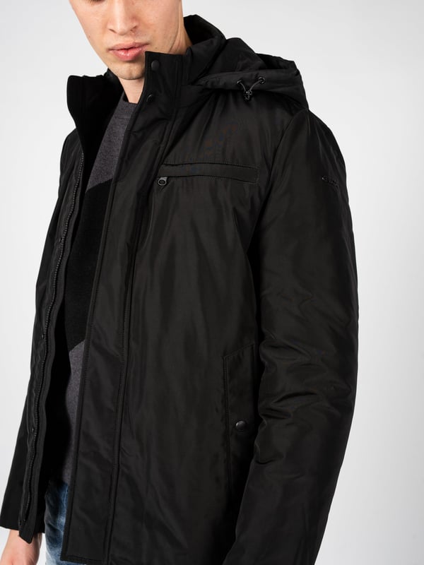 El diseño sencillo de esta chaqueta es la combinación perfecta de elegancia y comodidad, lo que hace que sea adecuada tanto para atuendos cotidianos como para estilismos más formales, y su corte minimalista realza el carácter moderno.

Con una capucha desmontable que proporciona protección adicional contra el viento y la lluvia, la chaqueta se convierte en una opción versátil para cualquier clima, ofreciendo al mismo tiempo la posibilidad de adaptarse a las necesidades individuales del usuario.

Cerrada con una cremallera logotipada y botones a presión, la chaqueta combina funcionalidad con un estilo único, añadiendo un sutil toque de la marca que seguramente atraerá la atención de los amantes de la moda.

En el frente tiene cuatro bolsillos, dos con cremallera y dos con botones a presión, que ofrecen soluciones prácticas para almacenar elementos esenciales, garantizando al mismo tiempo un acceso fácil y seguridad.

En la manga izquierda, un detalle de la empresa es un toque discreto pero elegante, que le da carácter a la chaqueta y subraya su exclusividad, permitiendo destacar entre la multitud.

Confeccionada con tejido de alta calidad, transpirable y resistente al agua, la chaqueta proporciona confort y protección en cualquier condición climática, cuidando al mismo tiempo de la adecuada circulación del aire y manteniendo la temperatura óptima del cuerpo.