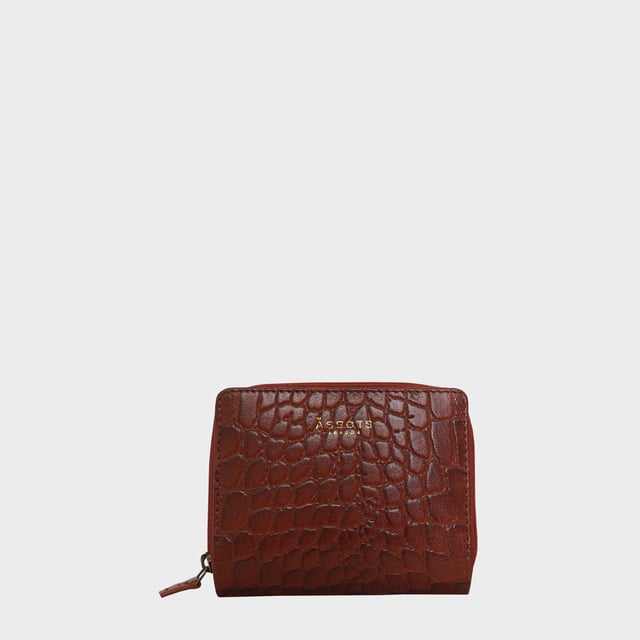 The 'Jolly' compact RFID equipped wallet purse is perfectly handcrafted with premium vintage Croc real leather for that designer look. This timeless design wallet purse easily fits in your bag or pocket featuring multiple card slots, slip pockets and a zip pocket. Organise your belongings with ease with 'Jolly' the perfect medium sized wallet purse.
Riveted closure for safe and secure storage. Zip compartment for you to store your coins and keys. Equipped with RFID technology to keep you safe from modern theft. Three card slots and three slip pockets for you to store your cards and notes. Compact size fitting easily in your bag or pocket. Fittings: Clean Brass. Composition: Body: 100% Genuine Leather. Lining: Polyester.
DISCLAIMER : All pictures shown are for illustration purpose only. Actual product colour may vary due to different ambience lighting or the screen display settings. Size- W11cm x H9.5cm x D2cm.