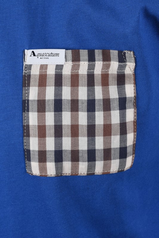 Aquascutum Club Check Pocket T-shirt in Royal Blue
Elevate your casual wardrobe with the Aquascutum Club Check Pocket T-shirt in Royal Blue. This classic crew neck tee offers a refined touch with its iconic Club Check patch pocket, a signature detail from the esteemed British brand.
 
 Crafted from premium, 100% organic jersey cotton, this short-sleeved t-shirt provides exceptional comfort and breathability for everyday wear. A subtle Aquascutum brand tab adds a discreet mark of quality. Perfect for layering or wearing on its own, this Royal Blue tee is a versatile staple that embodies understated luxury. 

 
Features

Iconic Club Check Pocket: A signature touch showcasing Aquascutum's heritage.
Premium Organic Cotton: Made from 100% organic cotton for superior comfort and a sustainable choice.   
Classic Crew Neck: A timeless design that pairs effortlessly with any outfit.
Short Sleeves: Ideal for warm weather or layering.
Aquascutum Brand Tab: Discreet branding for a touch of authenticity.
Soft Jersey Fabric: Provides a comfortable and relaxed fit.
Style code: AA_B005_TS007
