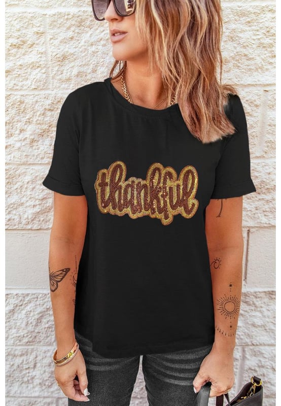 Black Sequined Thankful Round Neck Graphic Tee
  Perfect choice for the holiday season
  Round neck and shift fit for comfortable wear
  Thankful graphic with shiny sequins adds a meaningful message
  Soft and breathable material ideal for layering
  Available in multiple sizes