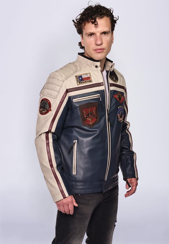 Top Gun Lederjacke TGJ1005 Die Jacke ist mit einem Baumwollfutter ausgestattet und mit den typischen Stickereien. Mit Reißverschlüssen an den Ärmeln und zwei verstellbaren Lederriemen an den Seiten ergibt sich eine ideale Passform. Zwei Seitentaschen mit Reißverschluss und eine Innentasche mit Klettverschluss bieten viel Stauraum. Die Jacke wird über einen geraden Reißverschluss geschlossen und kann zusätzlich über Druckknöpfe am Saum und Kragen geschlossen werden.