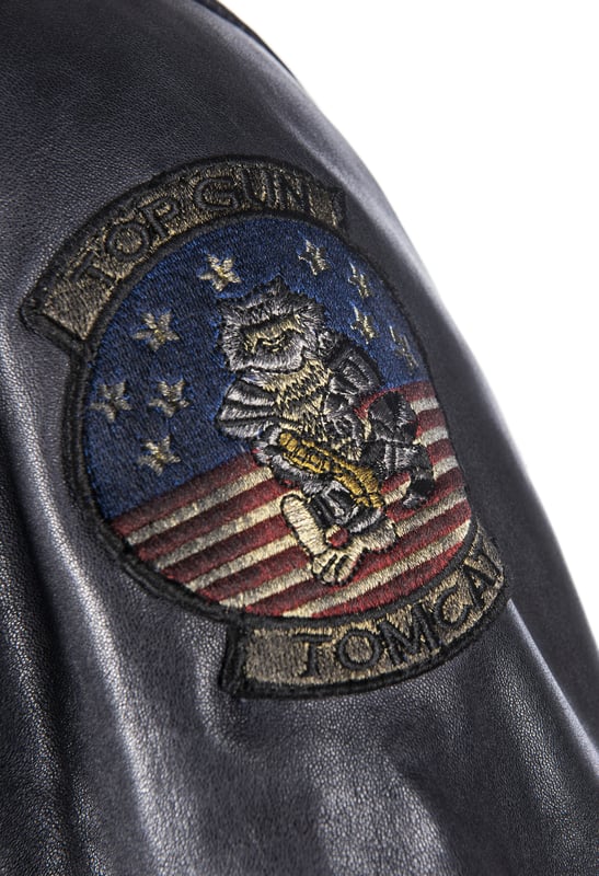 Der einzigartige Top Gun Stil spiegelt sich in dieser hippen Lederjacke in Blouson-Optik mit abnehmbaren Pelzkragen wieder. Die Jacke besteht aus weichem Lammleder. Zwei aufgesetzte Pattentaschen mit Knopfverschluss sind in diese hochwertige Jacke eingearbeitet. Die Jacke wird über einen geraden Reißverschluss geschlossen. Die legendären Top Gun Symbole sind mit Patches auf die Brust und Oberarme genäht. Durch den elastischen Strickbund an den Ärmelenden und am Saum bietet diese Jacke einen top Tragekomort.