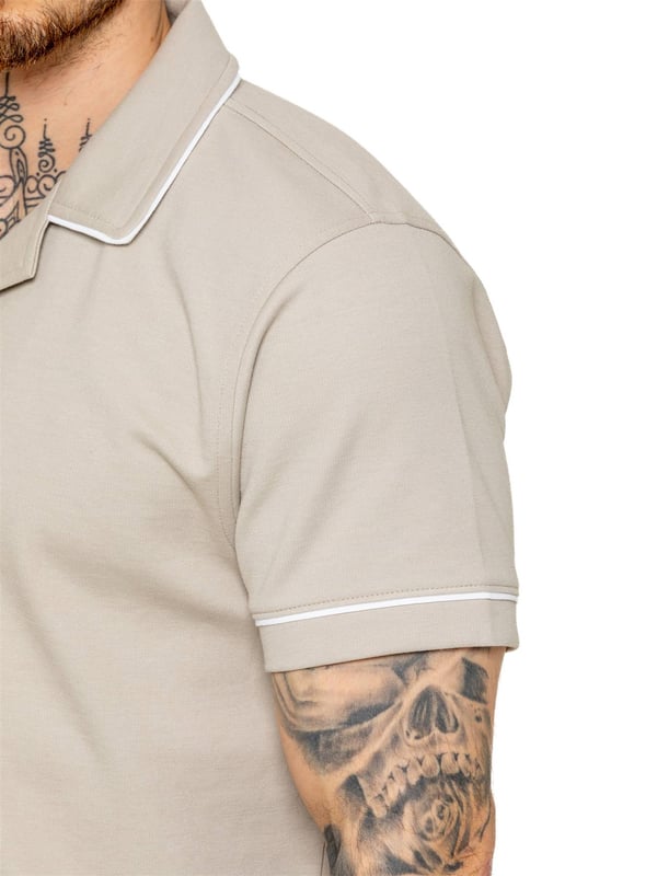 La camisa Enzo para hombre con ribetes es una prenda elegante y versátil, diseñada para ofrecer comodidad y sofisticación. Con un cuello abierto tipo revere y detalles de ribetes blancos a lo largo del cuello y las mangas, esta camisa abotonada ofrece un aspecto refinado pero relajado. Confeccionada con tela premium con elasticidad, garantiza libertad de movimiento sin perder su silueta estilizada. Con un ajuste regular, mangas cortas y un dobladillo cosido, esta camisa es perfecta para salidas informales o un estilo casual elegante.