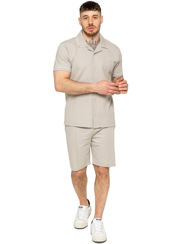 La camisa Enzo para hombre con ribetes es una prenda elegante y versátil, diseñada para ofrecer comodidad y sofisticación. Con un cuello abierto tipo revere y detalles de ribetes blancos a lo largo del cuello y las mangas, esta camisa abotonada ofrece un aspecto refinado pero relajado. Confeccionada con tela premium con elasticidad, garantiza libertad de movimiento sin perder su silueta estilizada. Con un ajuste regular, mangas cortas y un dobladillo cosido, esta camisa es perfecta para salidas informales o un estilo casual elegante.