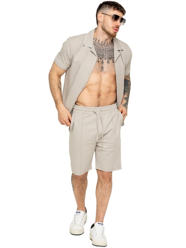 La camisa Enzo para hombre con ribetes es una prenda elegante y versátil, diseñada para ofrecer comodidad y sofisticación. Con un cuello abierto tipo revere y detalles de ribetes blancos a lo largo del cuello y las mangas, esta camisa abotonada ofrece un aspecto refinado pero relajado. Confeccionada con tela premium con elasticidad, garantiza libertad de movimiento sin perder su silueta estilizada. Con un ajuste regular, mangas cortas y un dobladillo cosido, esta camisa es perfecta para salidas informales o un estilo casual elegante.
