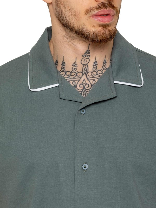 The Enzo Men's Piping Shirt is a stylish and versatile piece designed for both comfort and sophistication. Featuring a revere collar and white piping detail along the collar and sleeves, this button-up shirt offers a refined yet relaxed look. Crafted from premium fabric with stretch, it ensures ease of movement while maintaining a sleek silhouette. With a regular fit, short sleeves, and a stitched hem finish, this shirt is perfect for casual outings or smart-casual styling.