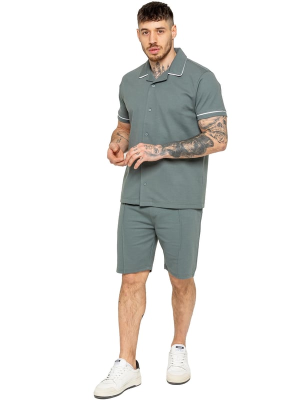 The Enzo Men's Piping Shirt is a stylish and versatile piece designed for both comfort and sophistication. Featuring a revere collar and white piping detail along the collar and sleeves, this button-up shirt offers a refined yet relaxed look. Crafted from premium fabric with stretch, it ensures ease of movement while maintaining a sleek silhouette. With a regular fit, short sleeves, and a stitched hem finish, this shirt is perfect for casual outings or smart-casual styling.