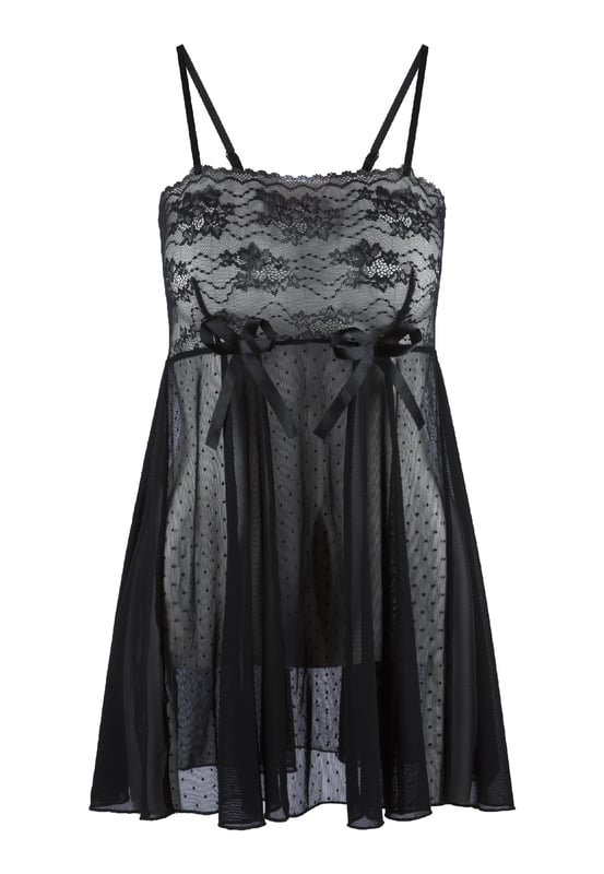 'In de diepten van zwarte lingerie schuilt een verhaal van mysterie.' De babydoll is gemaakt van zachte materialen en is semi-transparant. Het bovenste gedeelte is van zachte kant. Het lichaam is gemaakt van stippennet en is afgewerkt met twee speelse strikken. De schouderbanden van de babydoll zijn smal en verstelbaar.