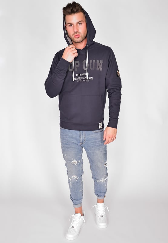 De unieke Top Gun stijl komt terug in deze moderne hoodie. Hij is voorzien van de typische patches op de bovenarm en unieke studs op de borst. Het elastische breisel bij de manchetten en tailleband zorgt voor een ideale pasvorm. De zachte stof en grote zak aan de voorkant bieden extra comfort. De hoodie heeft een capuchon met trekkoord en een stijlvolle print op de voorkant.