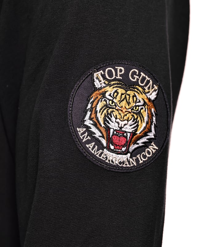 Der einzigartige Top Gun Stil spiegelt sich in diesem modernen Hoodie wieder. Er besitzt die typischen Patches auf dem Oberarm und einen einzigartigen Noppenschriftzug auf der Brust. Der elastische Strick am Ärmelabschluss und am Bund sorgen für eine ideale Passform. Der weiche Stoff und die große Fronttasche bieten zusätzlichen Komfort. Der Hoodie besitzt eine Kapuze mit Kordelzug und einen stylischen Print auf der Frontseite.
