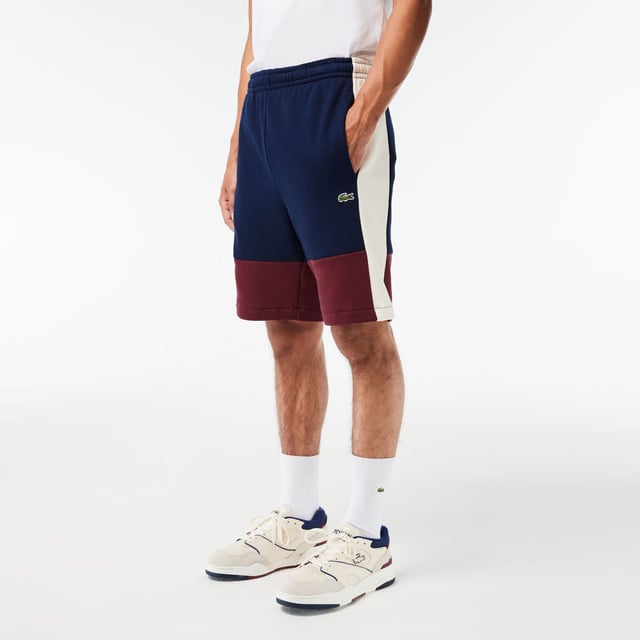 Lacoste Regular Fit Brushed Fleece Colourblock Jogger Shorts. Sporty colorblock shorts with a hip design and functional cut. Graphic style, soft texture. Urban pieces for contemporary looks, signed Lacoste.- Regular fit, straight cut.- Drawstring waist.- Side pockets.- Embroidered crocodile on front. Material: 80% Cotton, 20% Polyester. Ref: GH1319PIG.
