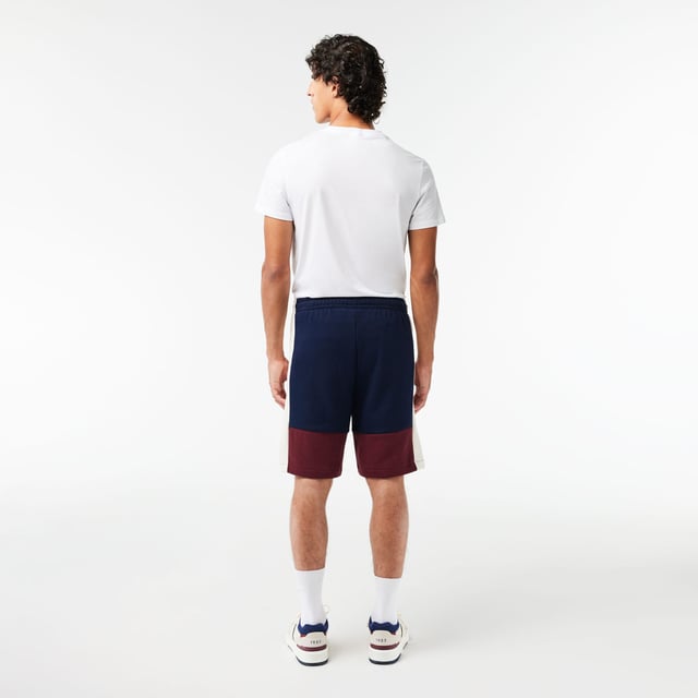 Lacoste Regular Fit Brushed Fleece Colourblock Jogger Shorts. Sporty colorblock shorts with a hip design and functional cut. Graphic style, soft texture. Urban pieces for contemporary looks, signed Lacoste.- Regular fit, straight cut.- Drawstring waist.- Side pockets.- Embroidered crocodile on front. Material: 80% Cotton, 20% Polyester. Ref: GH1319PIG.