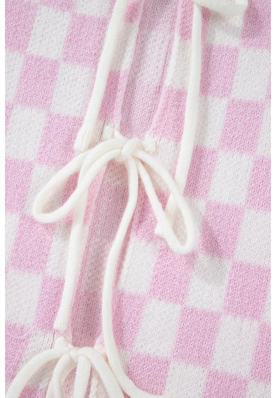 Patrón de cuadros en rosa claro  
Lazo en la parte frontal para un ajuste personalizable  
Mangas 3/4 con volantes para un toque femenino  
Estilo versátil para pantalones y faldas  
Alta elasticidad para comodidad y ajuste  
Material: 50% Viscosa 28% Poliéster 22% Poliamida
