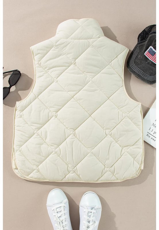 Chaleco acolchado de cuello alto en color beige con botones y bolsillos  
Diseño de cuello alto para mayor aislamiento y una apariencia elegante  
El diseño acolchado ofrece tanto moda como calidez  
Botonadura frontal para un uso fácil y un ajuste seguro  
Ideal para combinar con un suéter y jeans para un look acogedor  
Disponible en varias tallas: S M L XL 2XL  
Material: 100% Poliamida