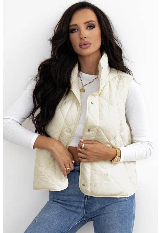 Chaleco acolchado de cuello alto en color beige con botones y bolsillos  
Diseño de cuello alto para mayor aislamiento y una apariencia elegante  
El diseño acolchado ofrece tanto moda como calidez  
Botonadura frontal para un uso fácil y un ajuste seguro  
Ideal para combinar con un suéter y jeans para un look acogedor  
Disponible en varias tallas: S M L XL 2XL  
Material: 100% Poliamida