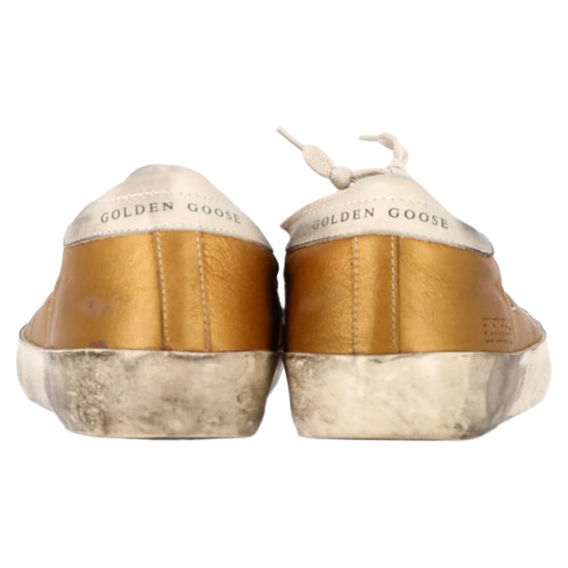 VINTAGE, RRP AS NEW
Add a touch of luxury to your casual wardrobe with the Golden Goose Superstar Perforated Sneakers in gold leather. These sneakers combine effortless street style with high-end craftsmanship, featuring a perforated design that enhances breathability and a sleek metallic gold finish that makes a bold statement. The signature distressed detailing gives them a cool, lived-in look, while the comfortable sole ensures all-day wearability.

Styling Tip: These versatile sneakers pair perfectly with everything from casual jeans and a tee to a chic midi dress for a laid-back yet stylish contrast. For an elevated street style look, pair them with leather leggings or a cropped denim jacket. Whether you're running errands or out for a coffee date, the Golden Goose Superstar sneakers will effortlessly add a touch of glam to any outfit.

 Golden Goose Superstar Perforated Sneakers in Gold Leather

Condition: Excellent
Signs of wear: No visible sign of wear. No Mark at insole.,  Very light mark at soles.
Packaging: None
Color: Gold
Material: Leather | leather
Size: EU | 38
Measurements: Heel height: 30; Insole length: 280
SKU: NAPPUGBSH458415W