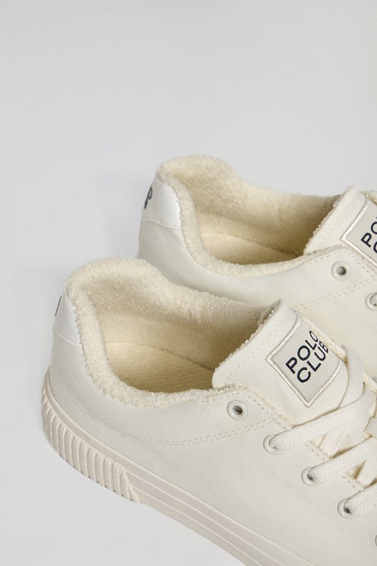 Klassischer Canvas-Turnschuh für Herren. Gummiertes Polo Club Logo auf der Fersenkappe aus Kunstleder. Markenetikett mit Ton-in-Ton-Nähten auf der Zunge. Schnürverschluss mit Logodetails. Innenfutter aus Frottee. Vulkanisierte Kautschuksohle.