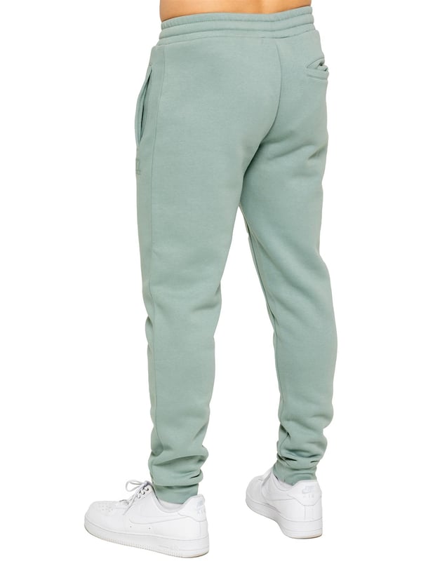 Experience ultimate comfort in our Enzo Mens Regular Fit Joggers. Made with a soft brushed back inner fleece lining, these joggers are perfect for casual wear. The cuffed leg design and elasticated waist with drawstrings provide the perfect fit. With 2 side slash pockets, you can easily carry your essentials.