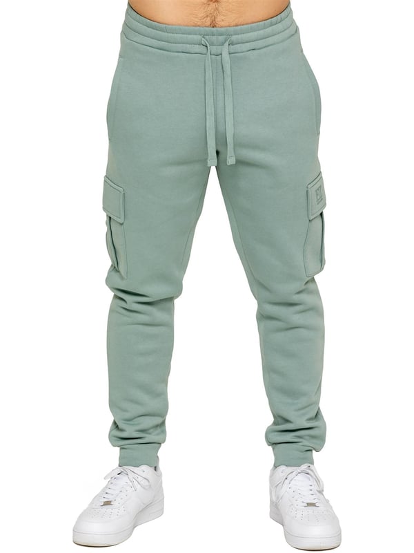Enzo | Mens Cargo Joggers Experience superior comfort and style with Enzo Men's Regular Fit Cargo Joggers! Crafted with a brushed back inner fleece lining, these joggers are designed to keep you cozy all day long. Perfect for casual wear, they feature convenient 2 side slash pockets and 2 cargo pockets, providing ample storage space for your essentials. Stay on-trend with the cuffed leg design, offering a modern silhouette and added comfort.