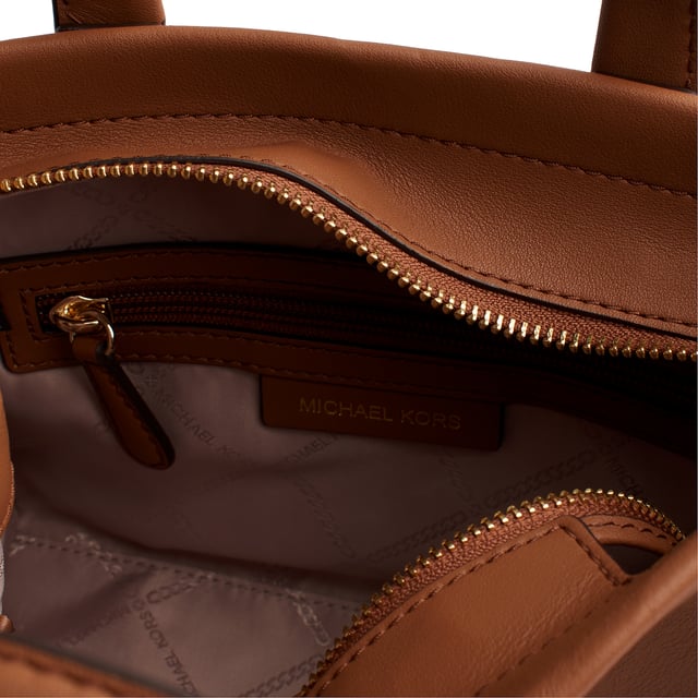 Presume de estilo con el bolso satchel de Michael Michael Kors. La construcción de cuero flexible garantiza un aspecto exquisito, mientras que el adorno del logotipo con tacto le aporta un toque sutil. Completo con dos asas de media caña, una correa de tela desmontable, herrajes de metal en tono dorado, un compartimiento y un bolsillo con cremallera y deslizante.

Detalles:
- Tipo de accesorio: Bolso satchel.
- Material: Piel vacuna.
- Textura: Lisa.
- Herraje: En tono dorado.
- Logo de MK en relieve.
- Detalles interiores: Bolsillo trasero con cierre y un bolsillo liso frontal.
- Detalles exteriores: Correa de tela desmontable y ajustable.
- Cierre: Superior, de cremallera.

Michael Kors cuenta en cada uno de sus accesorios con una colección de fuerte identidad, ofrece una mezcla fresca de tendencias, colores y siluetas que nunca pasan de moda, con estilo y actitud urbana. Cada bolso satchel mujer diseñado por Michael Kors, es un lujo accesible con un toque de glamour moderno, inesperado y cómodo que ofrece una pieza para cada ocasión.
 Medidas: 25 cm x 18 cm x 8,5 cm
 Composición: 100% Piel
 Cuidados:
Limpiar con un paño seco y suave.
Evitar la exposición prolongada al sol y la humedad.
No aplicar productos abrasivos en la piel.
Evitar el contacto con líquidos y superficies ásperas.