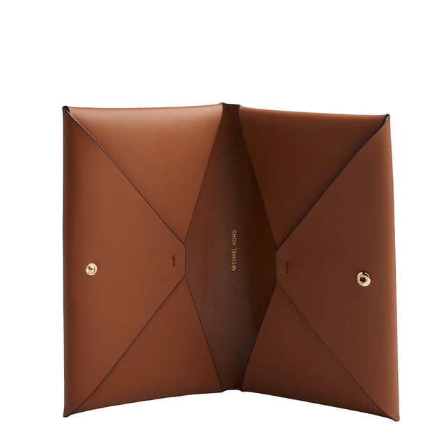 Domina el arte de viajar con esta cartera 3 en 1. Este modelo combina una fabricación en piel suave con nuestros sofisticados apliques. En el interior, incluye dos tarjeteros extraíbles con el exclusivo logotipo imperio estampado. Uno está diseñado para meter la tarjeta de embarque y el pasaporte, y el otro está pensado para guardar dinero en efectivo y monedas sueltas. Es el regalo perfecto para las personas que vuelan con frecuencia.

Detalles:
- Tipo de accesorio: Cartera grande.
- Material: Piel.
- Herraje: En tono dorado.
- Logo imperio de Michael Kors.
- Detalles interiores: 2 bolsillos, cartera y bolso pequeño de viaje extraíbles.
- Cierre: De botón a presión.
- Viene en caja exclusiva y elegante.

Cada cartera mujer diseñado por Michael Kors, es un lujo accesible con un toque de glamour moderno, inesperado y cómodo que ofrece una pieza para cada ocasión.
 Medidas: 21 cm x 12,7 cm x 3,8 cm
 Composición: 100% Piel
 Cuidados:
Limpiar con un paño seco y suave.
Evitar la exposición prolongada al sol y la humedad.
Evitar el contacto con líquidos y superficies ásperas.