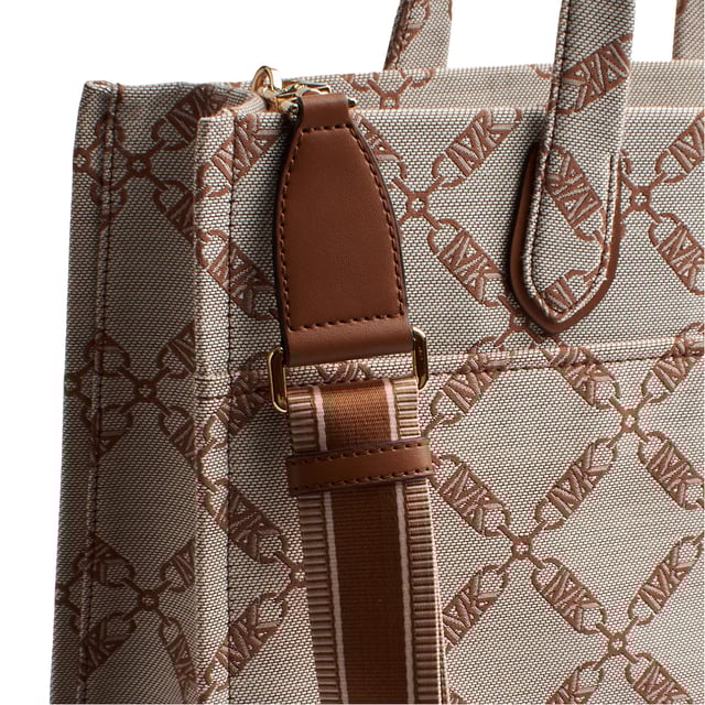 The Michael Kors Gigi tote is the perfect complement to virtually any look thanks to its neutral-toned jacquard chain and logo pattern. The large rectangular silhouette is the perfect size to carry just your everyday essentials and includes a versatile crossbody strap. Inside, there are convenient pockets for your keys and phone.

 Details:
 - Accessory Type: Tote Bag.
 - Material: Synthetic material with the repeated Empire logo.
 - Interior details: Back zipper pocket, 2 front pockets.
 - Exterior details: Front pocket with magnetic closure.
 - Handles: Double.
 - Includes shoulder strap and storage bag.
 - Closure: No closure.

 Each of Michael Kors' accessories collections boasts a strong identity, offering a fresh mix of timeless trends, colors, and silhouettes, combined with urban style and attitude. Each women's tote bag designed by Michael Kors is an affordable luxury with a touch of modern, unexpected, and comfortable glamour, offering a piece for every occasion.
 Measures: 39.4 cm x 29.8 cm x 13.3 cm
 Composition: 53.2% Cotton, 46.8% Polyester
 Care:
Clean with a soft, dry cloth.
 Avoid prolonged exposure to the sun and humidity.
 Avoid contact with liquids and rough surfaces.